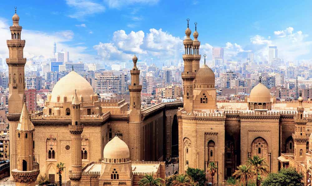 Vista de la ciudad de El Cairo, Egipto, con mezquitas de arquitectura islámica en primer plano y rascacielos al fondo