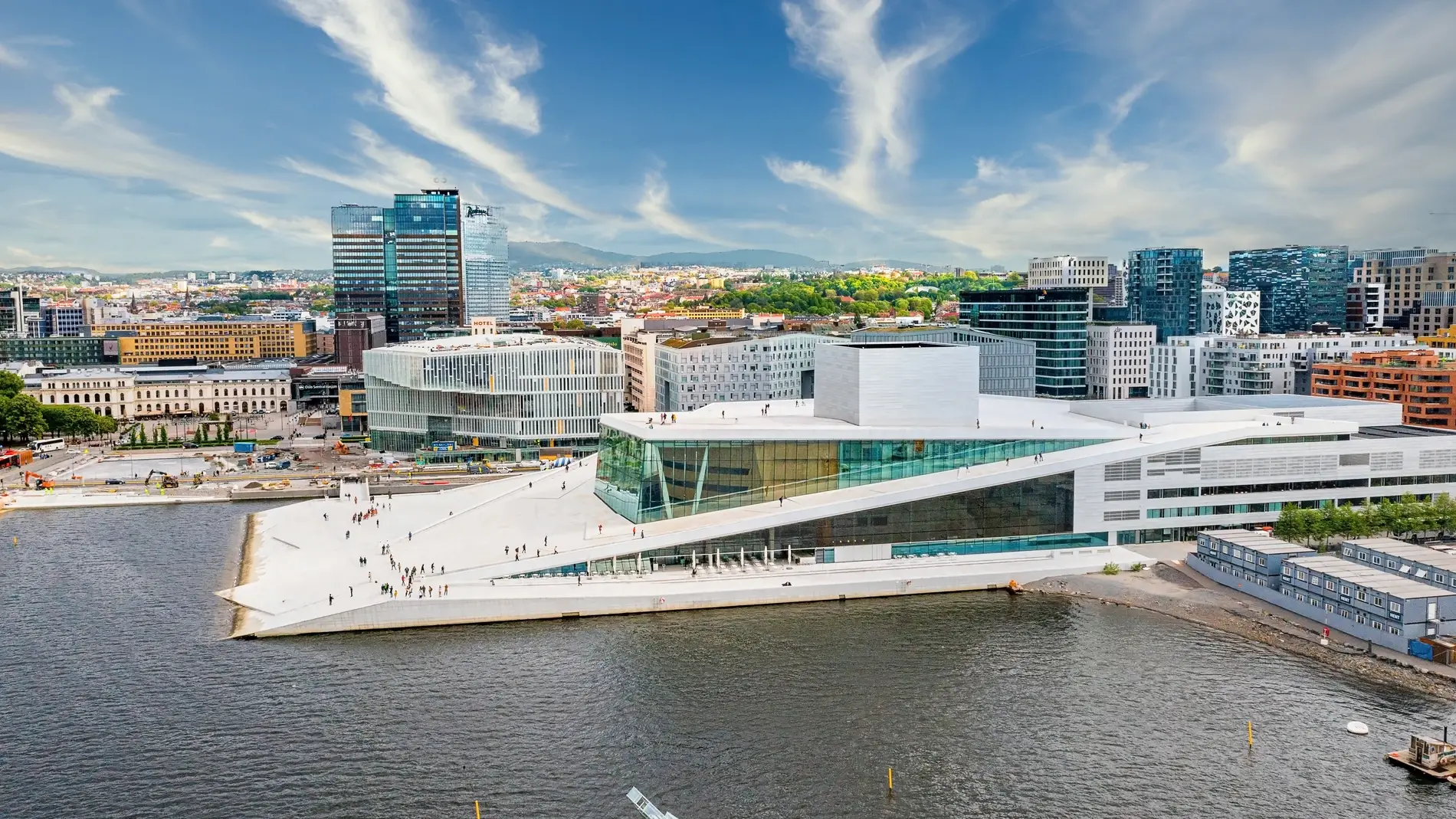 Fotografía del edificio de la Ópera de Oslo con la ciudad de Oslo al fondo.